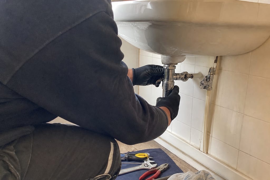 mains ajustent siphon sous lavabo ancien